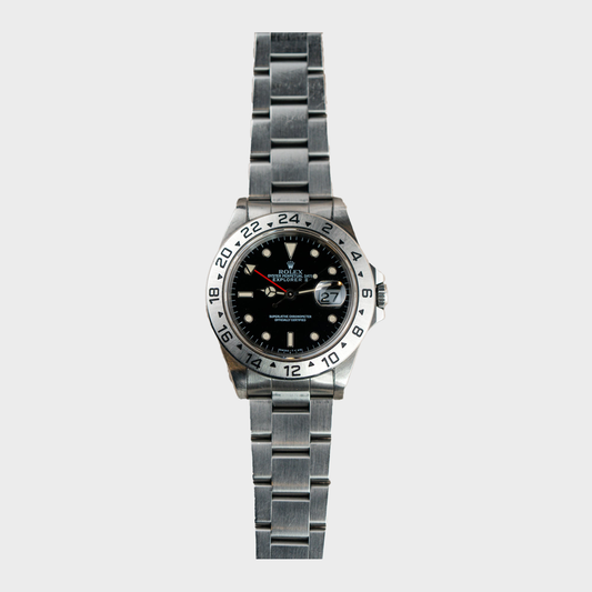Silver watch with black dial on a light gray background