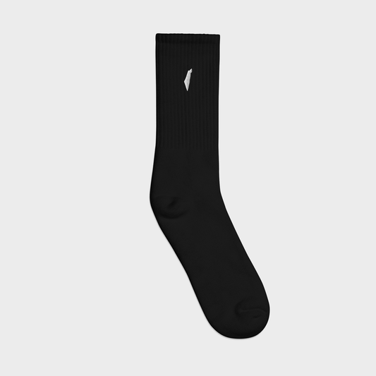 Black sock with a white logo on a light gray background